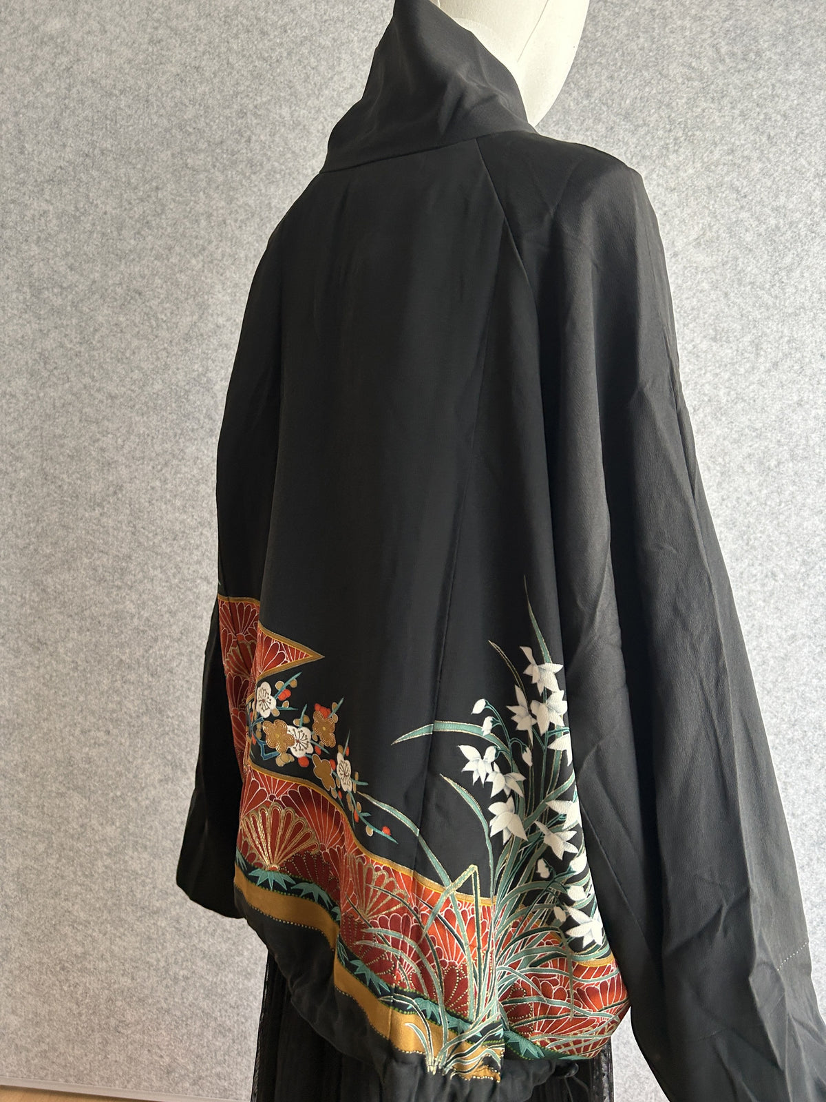 Black kimono jacket with red hem band and white flowers, back side view