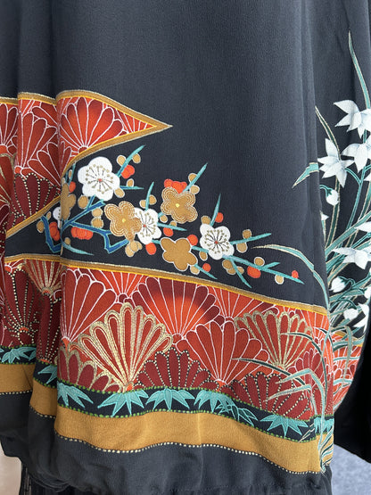 Black kimono jacket, detail of plum blossoms and red band on back hem