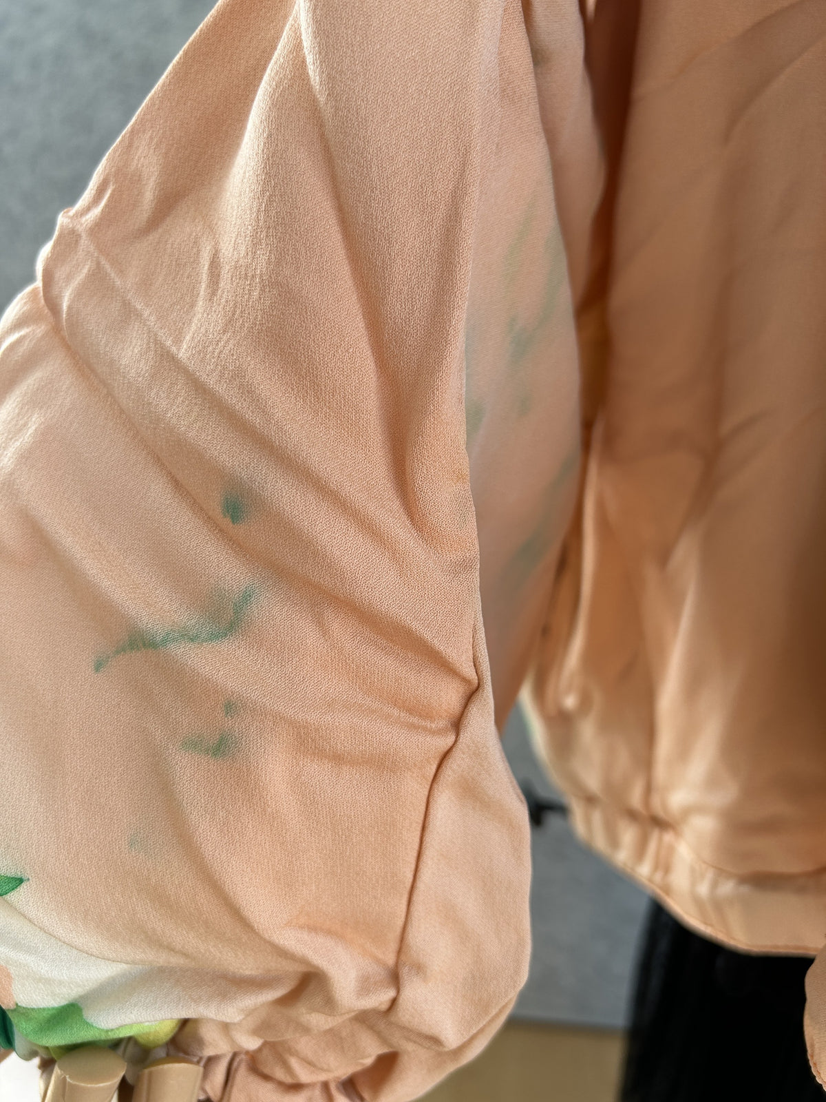 Peach kimono jacket sleeve with gathered cuff and faint green marks, detail
