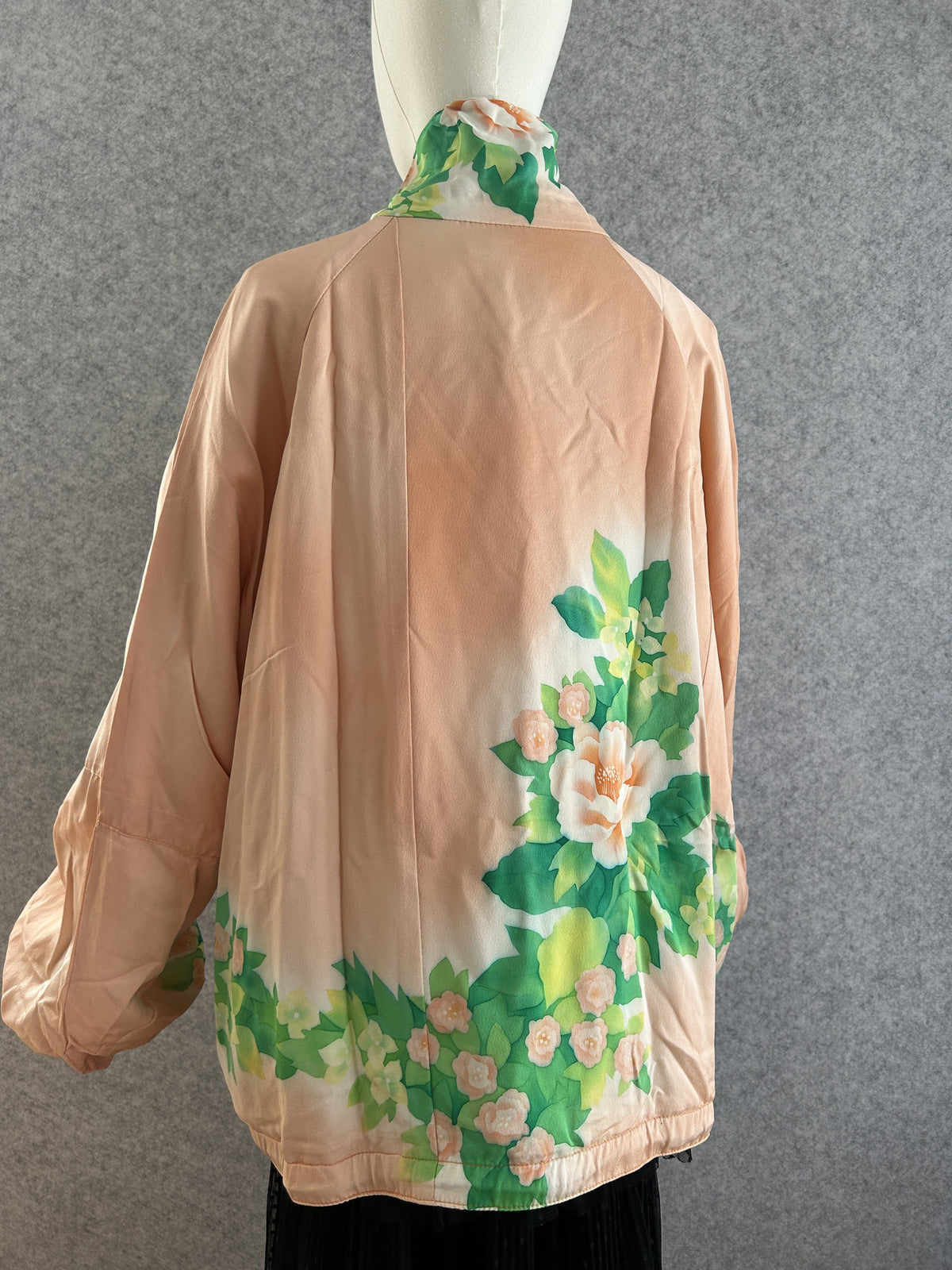 Peach high collar kimono jacket with flowers along the hem, back view