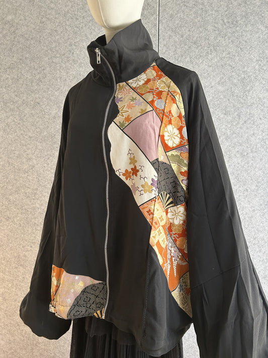 Black high collar kimono jacket with orange and gold patterned panel, front view
