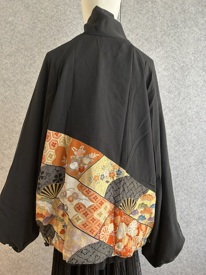 Black high collar kimono jacket with colourful patterned band, back view