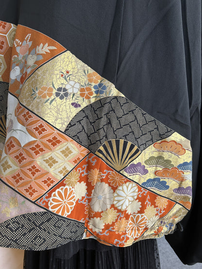 Black kimono jacket lower back with orange and gold patterned panel, detail