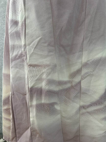 Detail of wave pattern along the panelled hem of the lilac dress