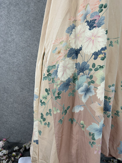 Detail of white and pink chrysanthemums with blue-grey leaves on peach silk