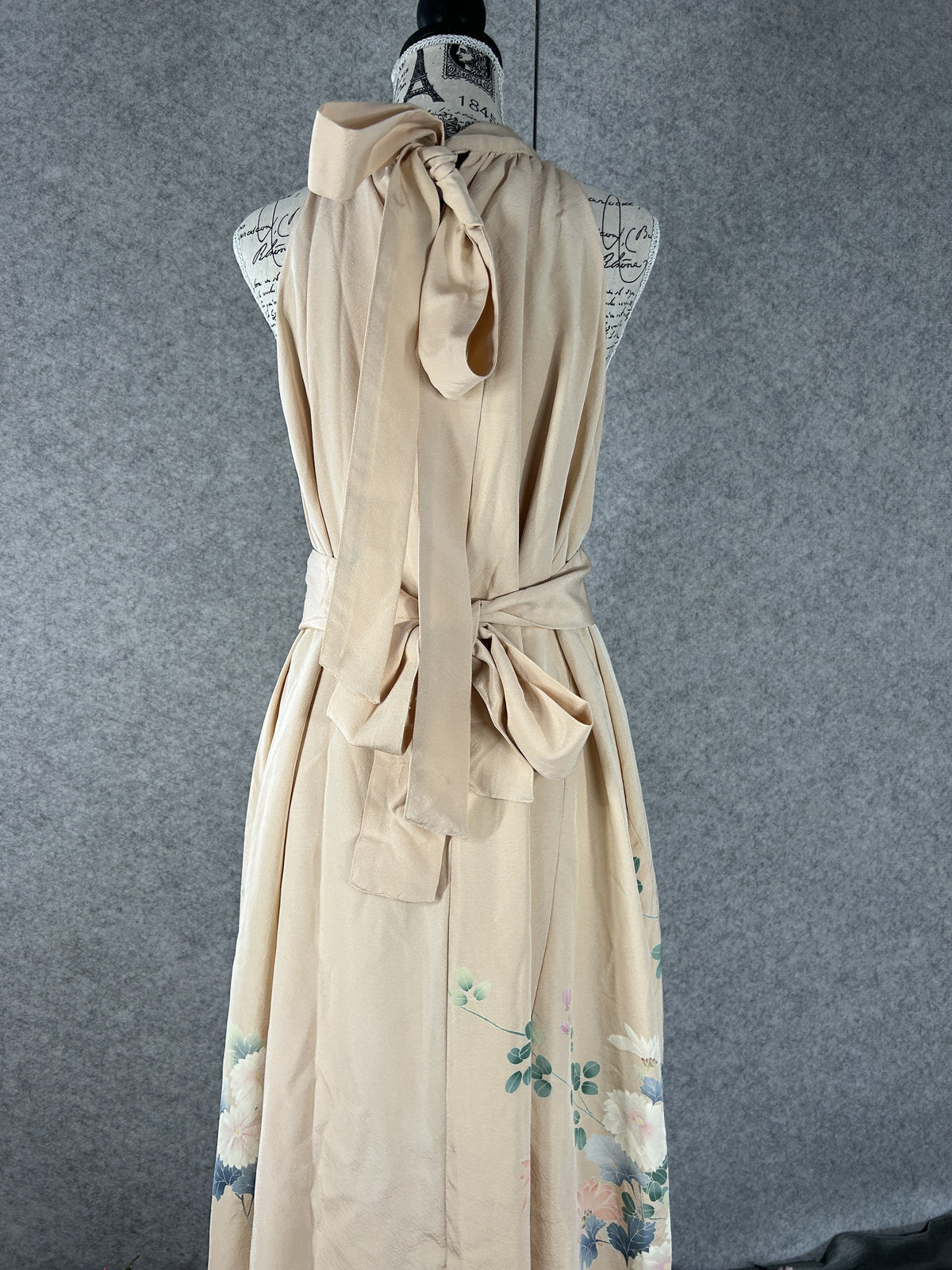 Back view of peach halter dress with neck ties and sash tied in a bow