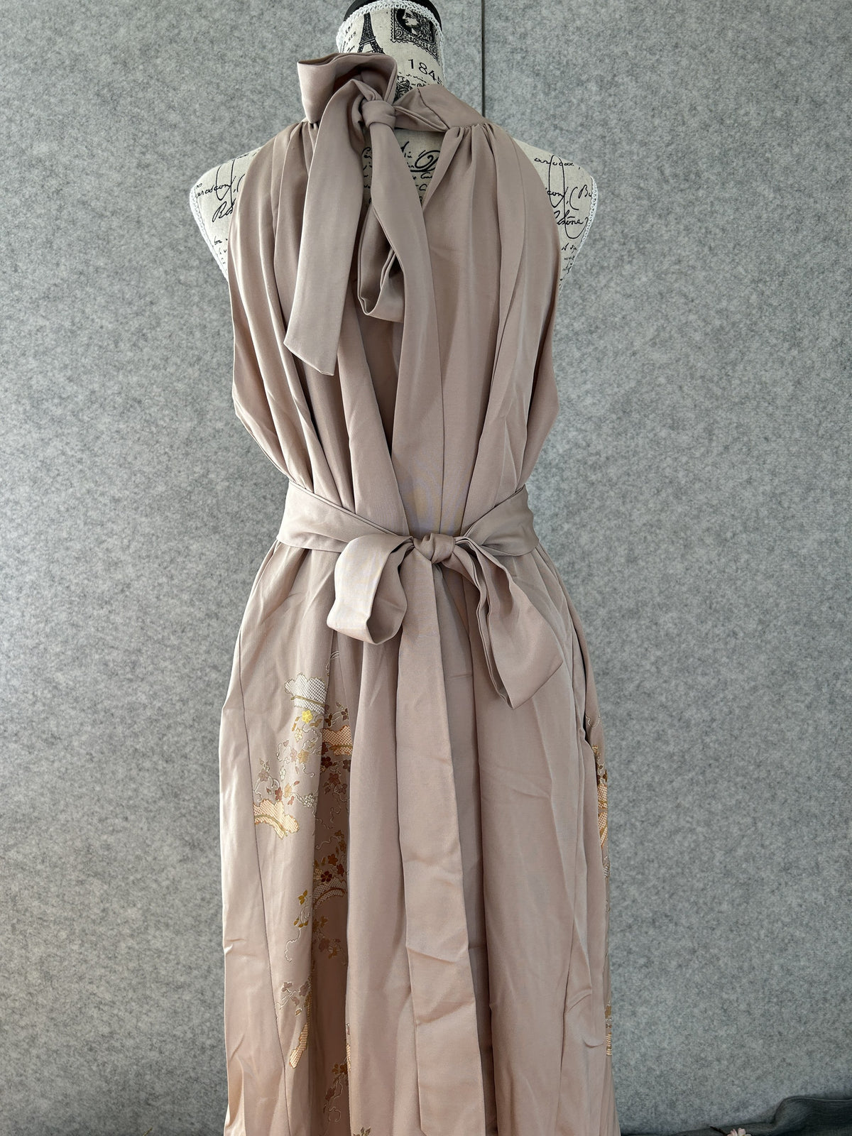 Beige kimono halter dress with neck bow and sash tied, back view