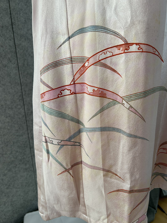 Detail of red, blue and green grass blades on pale pink kimono silk