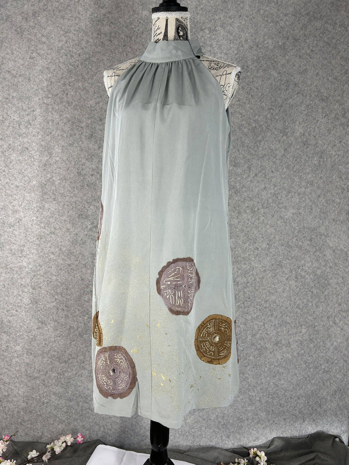 Sage green kimono halter dress with round mauve and bronze medallions, front view