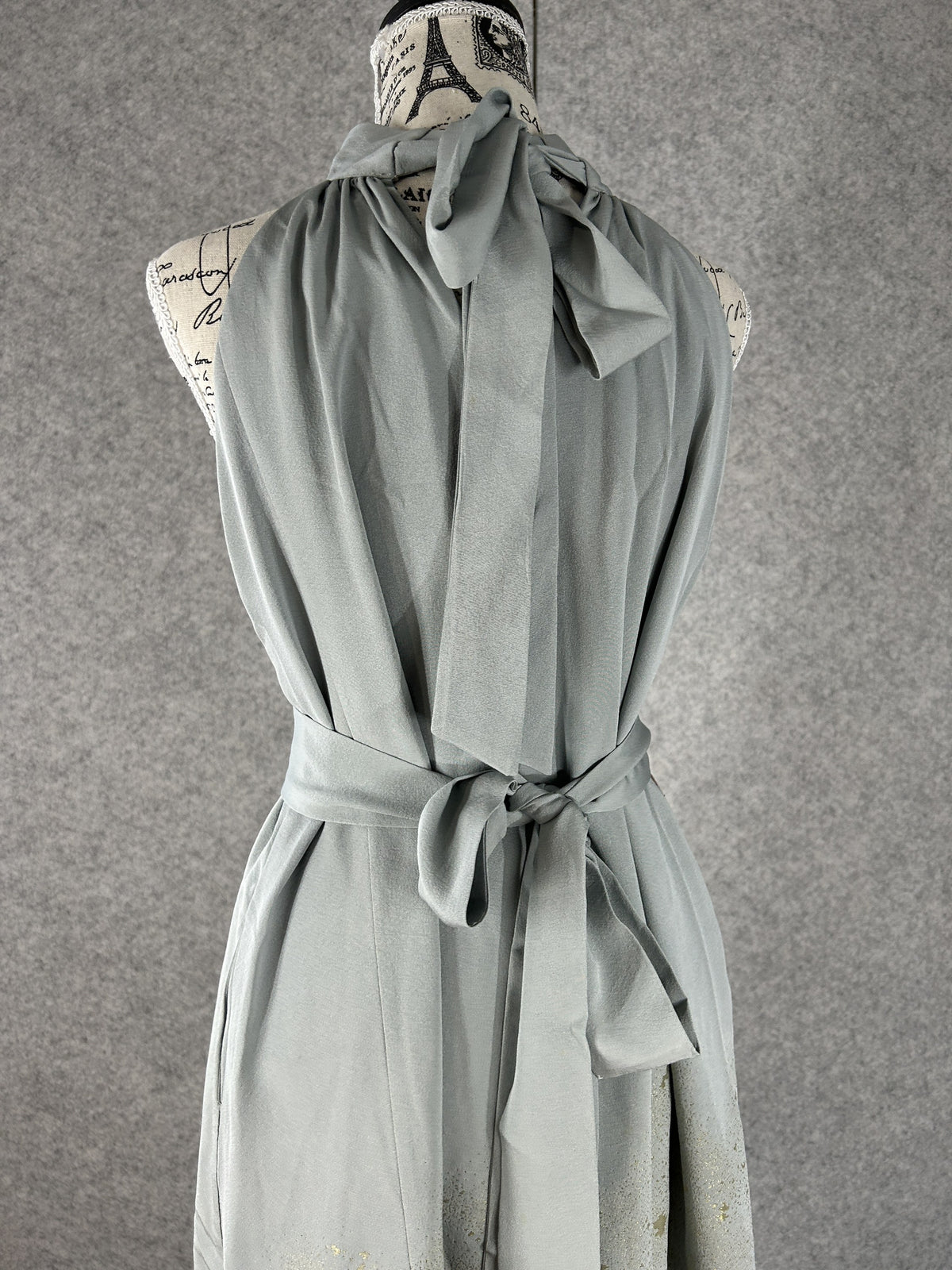 Back view of sage green halter dress with neck ties and sash bow
