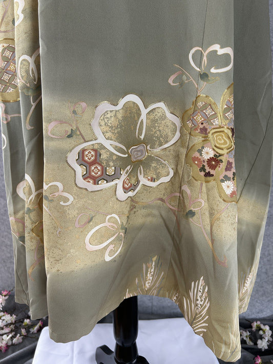 Detail of white and gold plum blossom motifs on sage green kimono silk