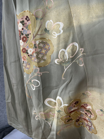 Detail of patterned blossom shapes with small flowers on sage green silk
