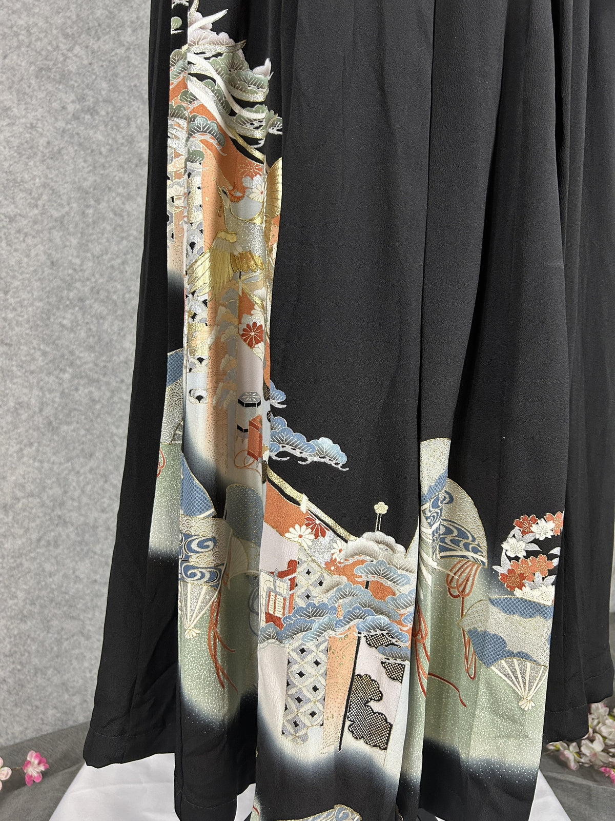 Black upcycled tomesode kimono hakama pants with a gold phoenix and fans, close-up of the hem with fans and clouds