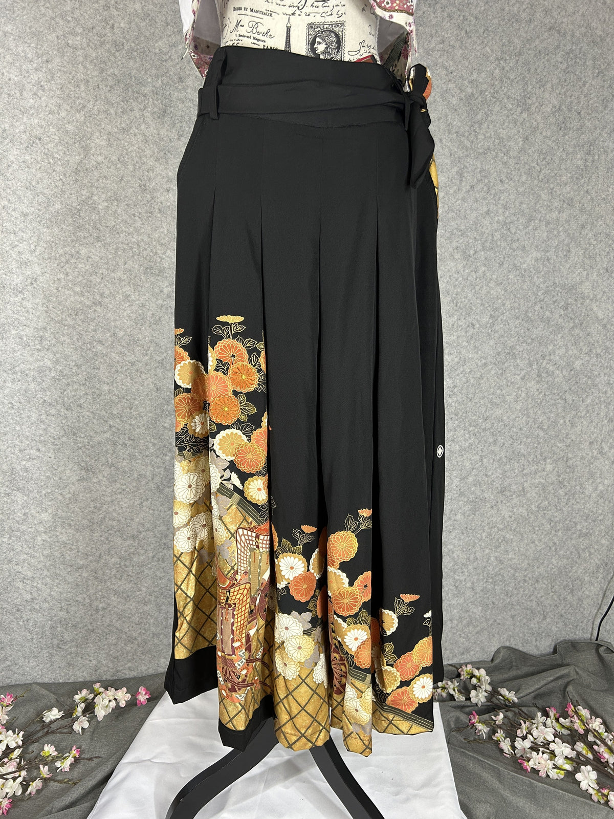 Black upcycled tomesode kimono hakama pants with orange and gold chrysanthemums, front view