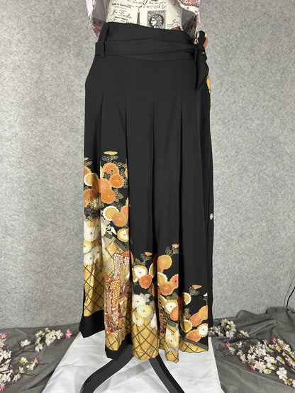 Black upcycled tomesode kimono hakama pants with orange and gold chrysanthemums, front view
