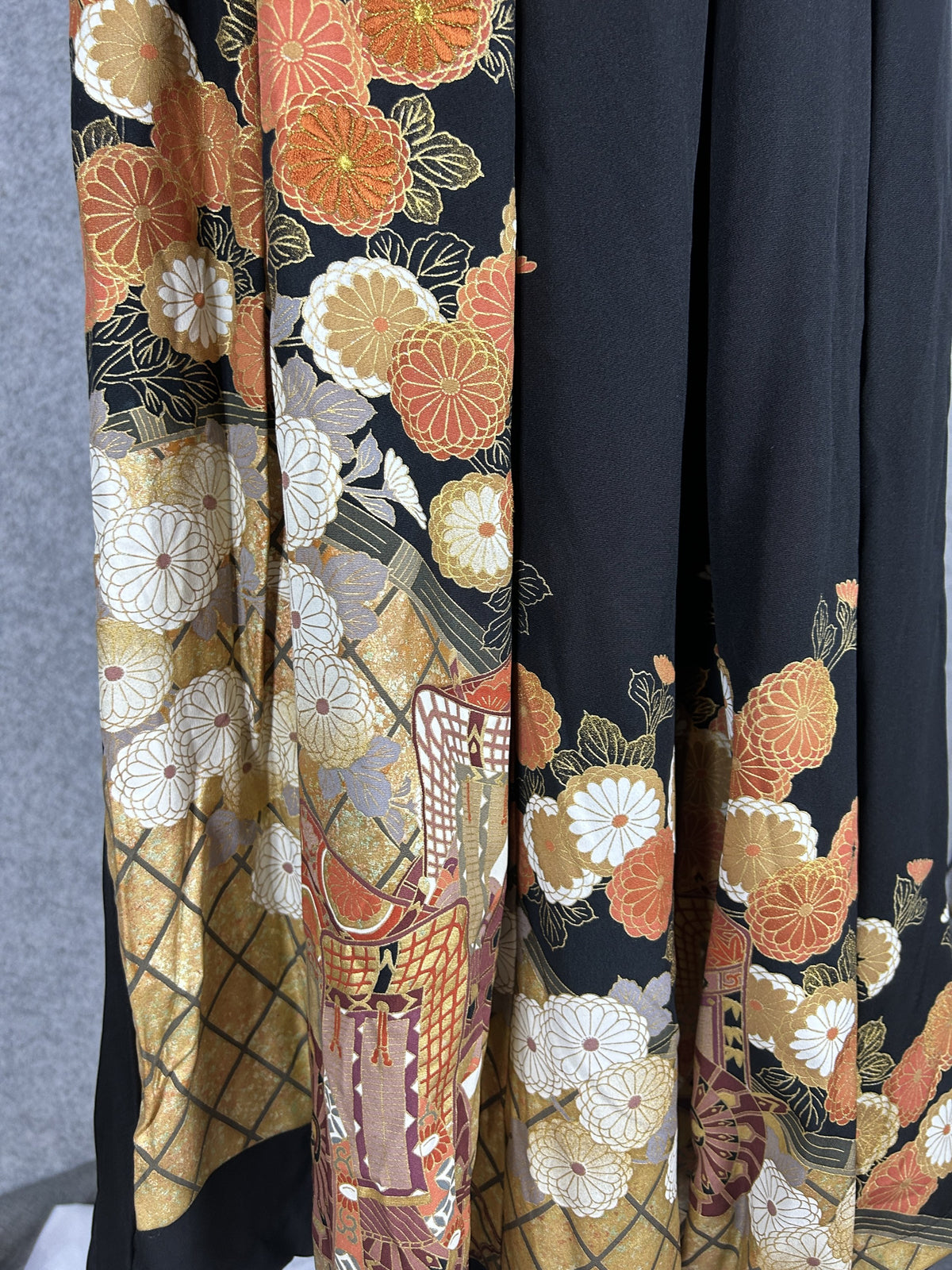Black upcycled tomesode kimono hakama pants with orange and gold chrysanthemums, detail of the chrysanthemums and ox cart on the hem