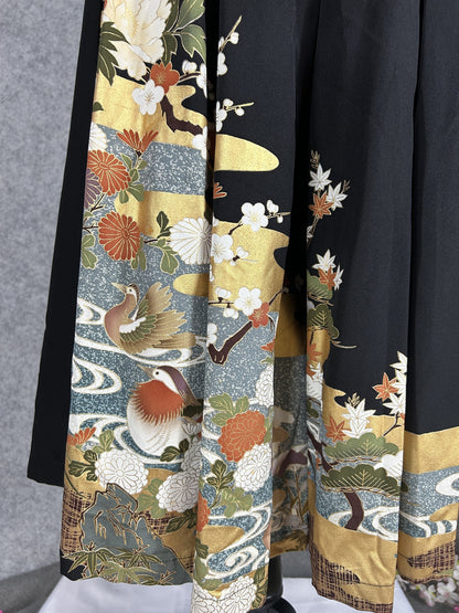 Black upcycled tomesode kimono hakama pants with mandarin ducks and peonies, close-up of the hem with ducks and plum blossoms
