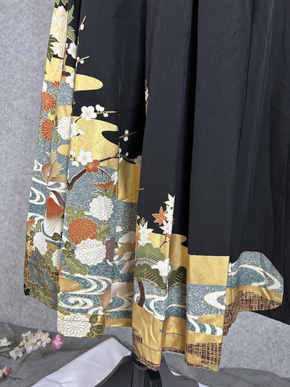 Black upcycled tomesode kimono hakama pants with mandarin ducks and peonies, back view of the pleated hem