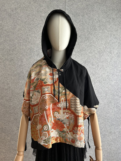 Black hooded kimono poncho with orange floral and bird panel, front view