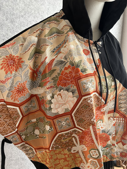 Black hooded kimono poncho, detail of bird, flowers and hexagon pattern