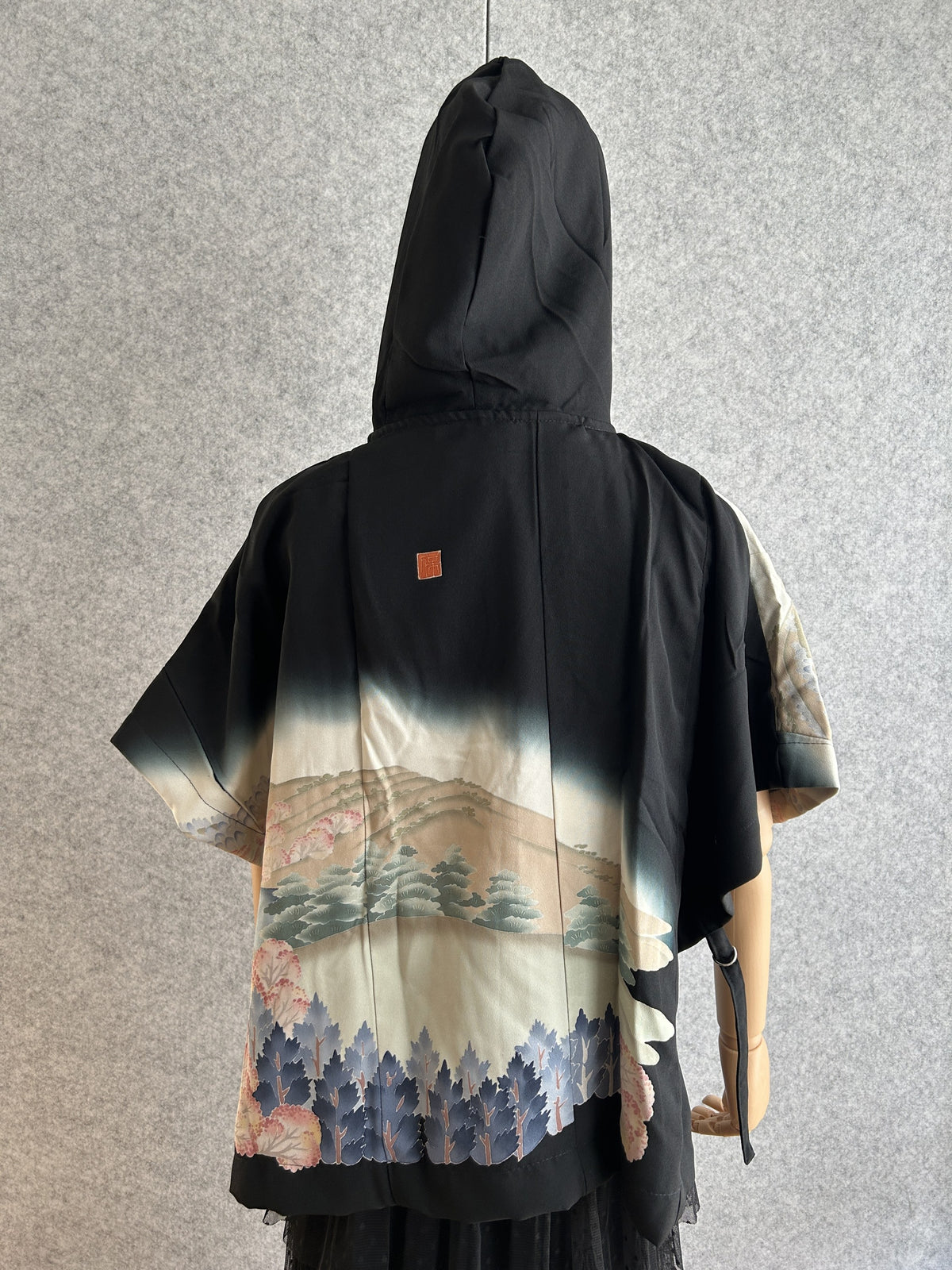 Black and cream hooded kimono poncho with landscape scene, back view