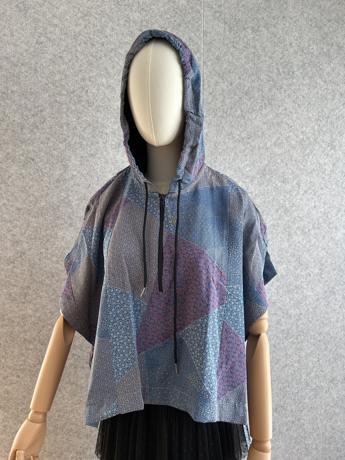 Blue hooded kimono poncho with patchwork of small patterns, front view