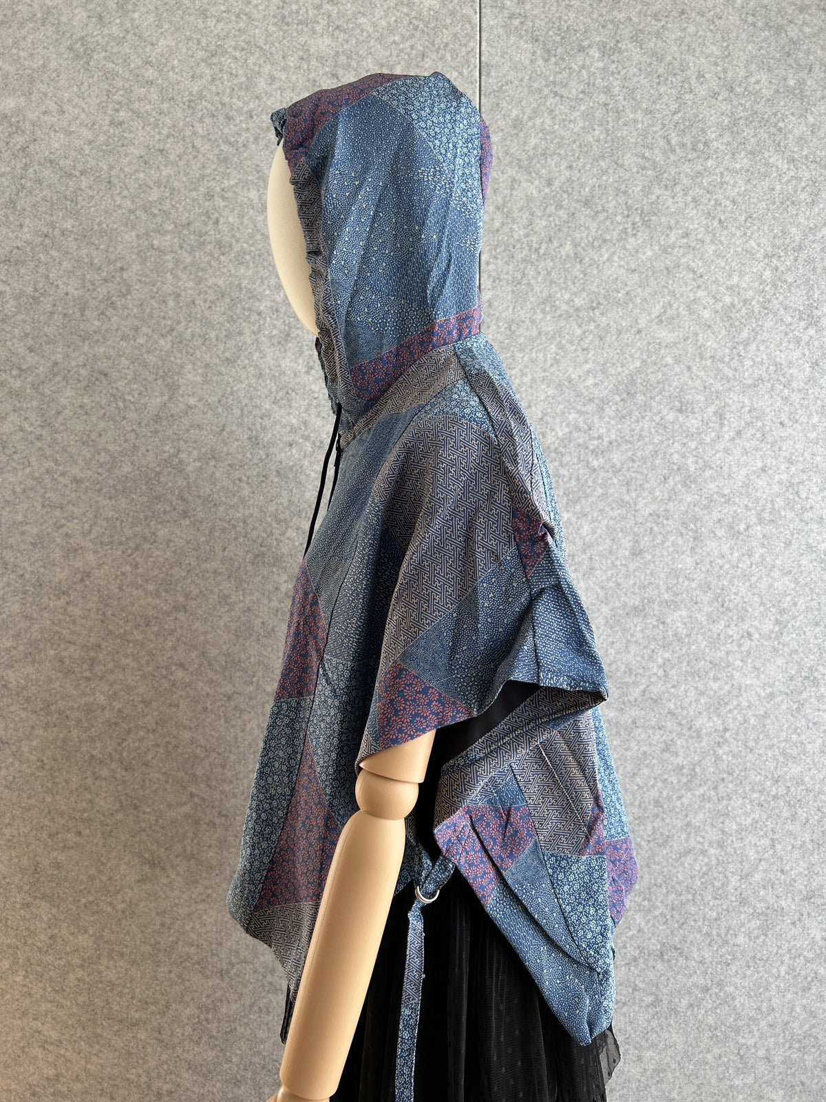 Blue hooded kimono poncho with patchwork of small patterns, side view