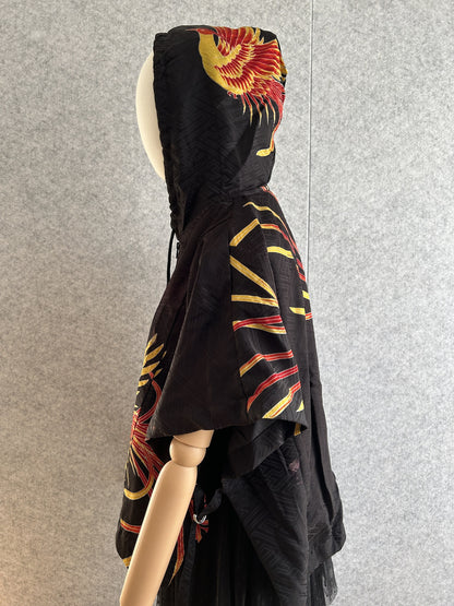 Black hooded kimono poncho with yellow and red bird motif, side view