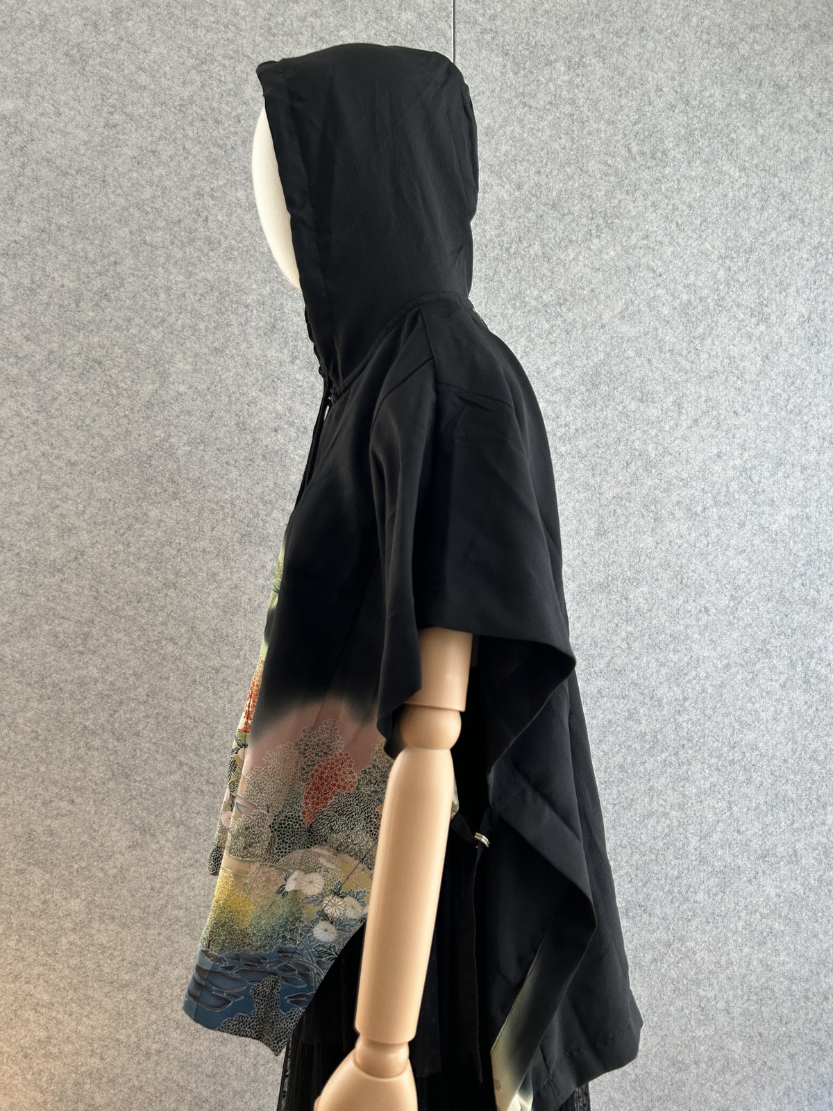 Black hooded kimono poncho with landscape on the front, side view