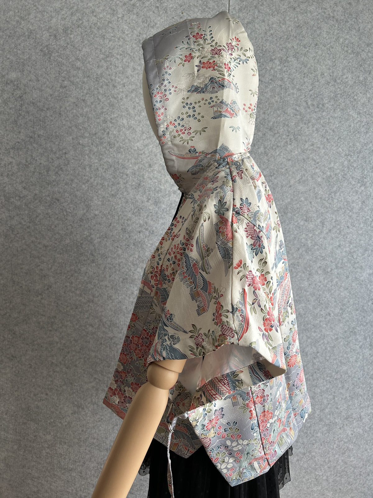 Cream hooded kimono poncho with red and blue floral scene, side view