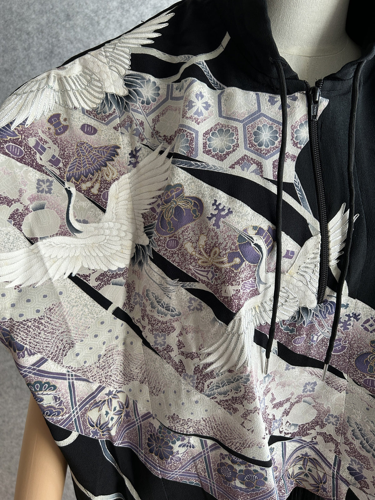 Black hooded kimono poncho, detail of white cranes and purple ornaments