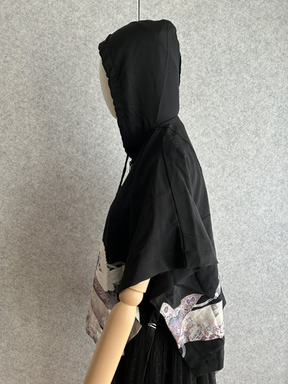 Black hooded kimono poncho with purple patterned hem, side view