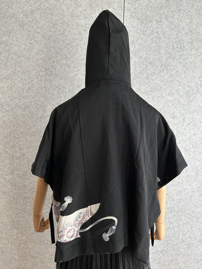 Black hooded kimono poncho with small purple patterned corner, back view