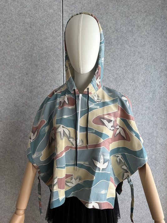 Teal blue hooded kimono poncho with yellow and red waves, front view