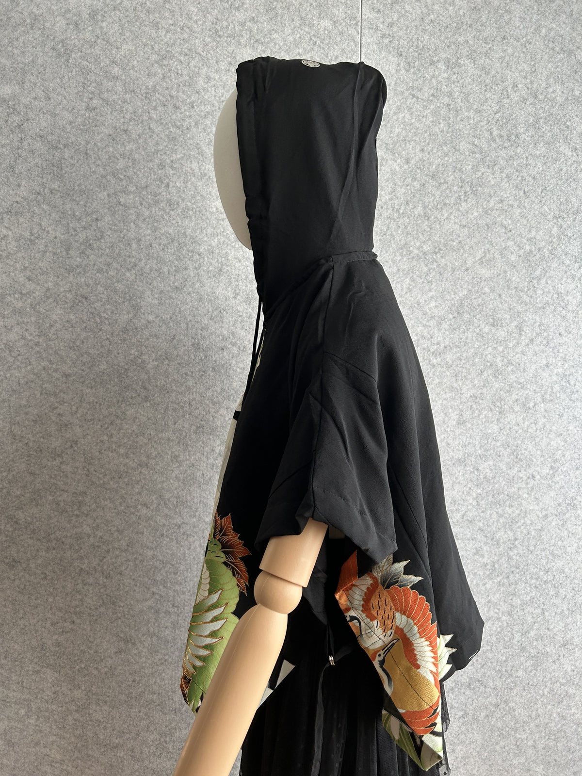 Black hooded kimono poncho with crane motif at hem, side view