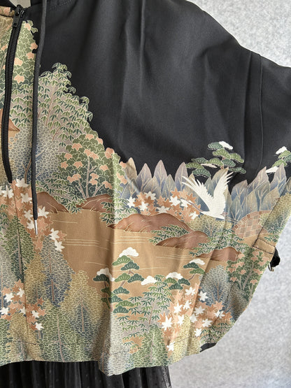 Black hooded kimono poncho, detail of landscape with cranes on the sleeve