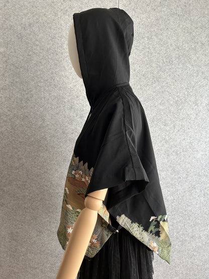 Black hooded kimono poncho with landscape pattern at the hem, side view