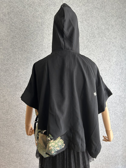 Black hooded kimono poncho with small landscape corner at the hem, back view