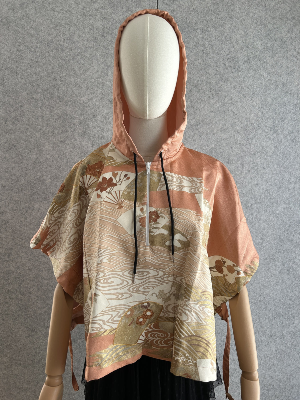 Salmon pink hooded kimono poncho with cream and gold fan pattern, front view