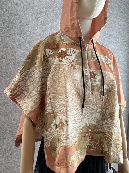 Salmon pink hooded kimono poncho with fan and wave pattern, angled front view