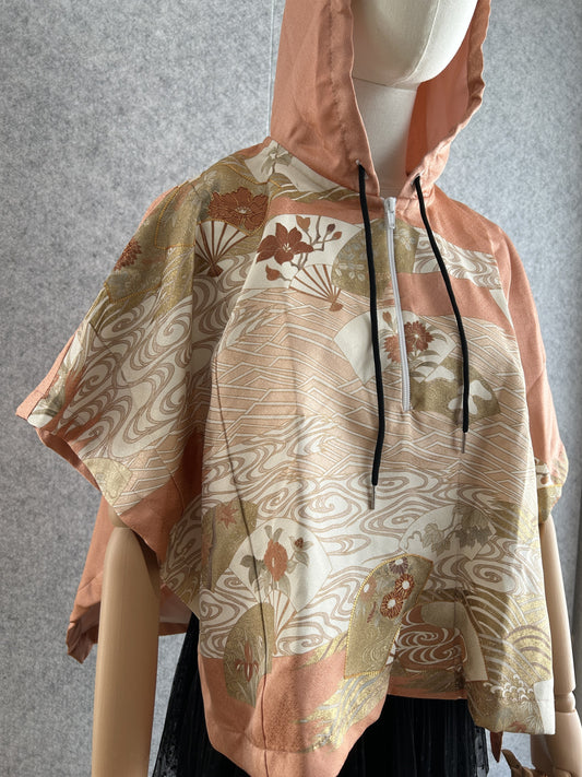 Salmon pink hooded kimono poncho with fan and wave pattern, angled front view