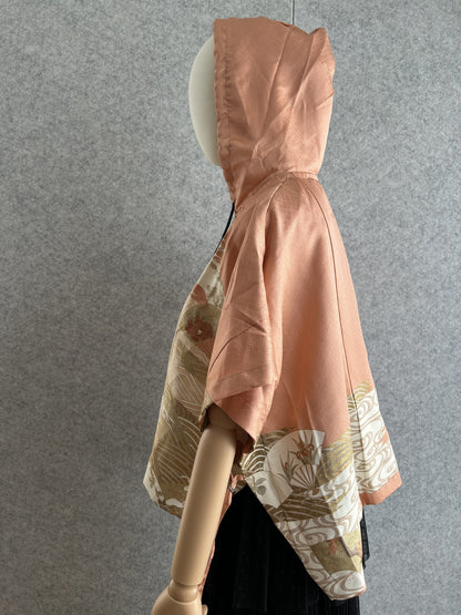Salmon pink hooded kimono poncho with fan pattern at the hem, side view