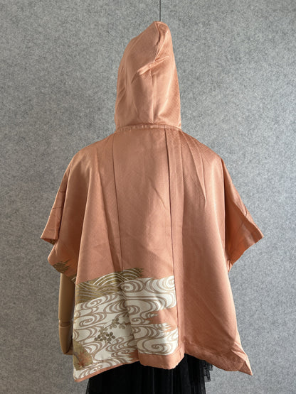 Salmon pink hooded kimono poncho with cream wave band at the hem, back view