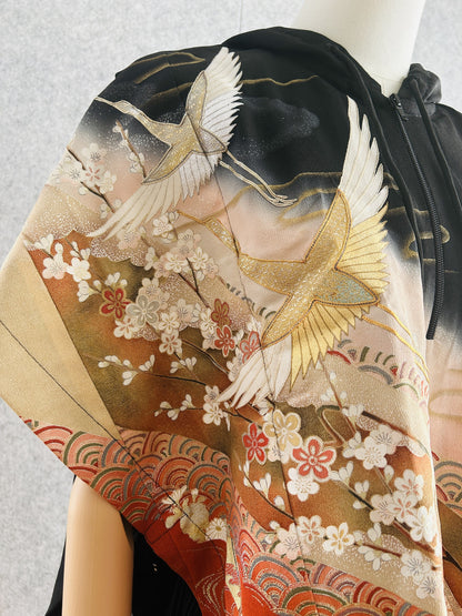 Black hooded kimono poncho, close-up of white and gold cranes over blossoms
