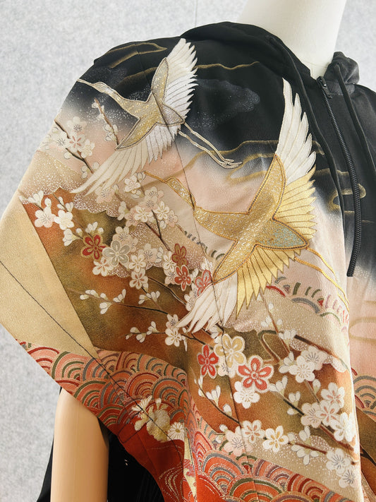 Black hooded kimono poncho, close-up of white and gold cranes over blossoms