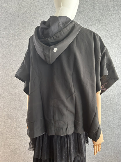 Black hooded kimono poncho with small white crest on hood, back view