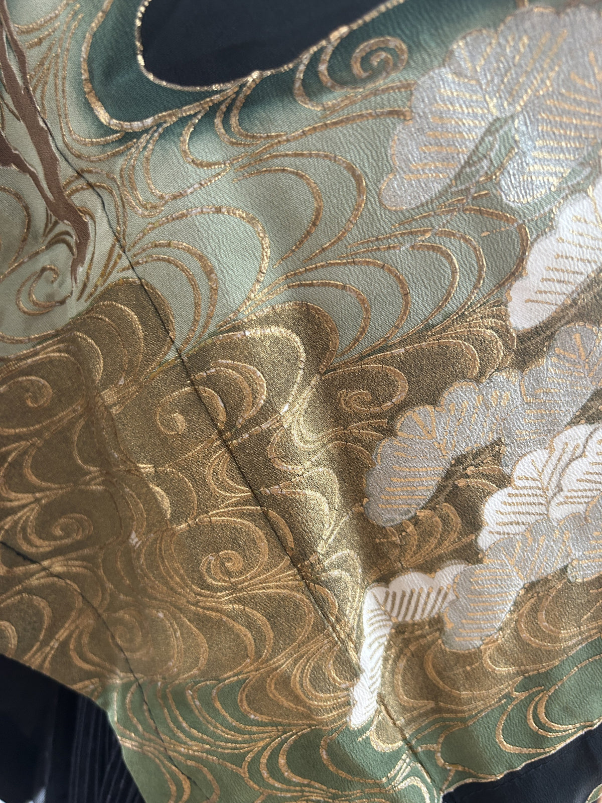 Detail of gold and green swirling water pattern with white pine clusters