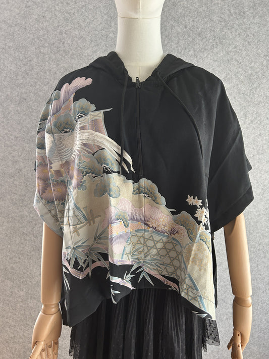 Black hooded kimono poncho with pastel bird, pine and fence scene, front view
