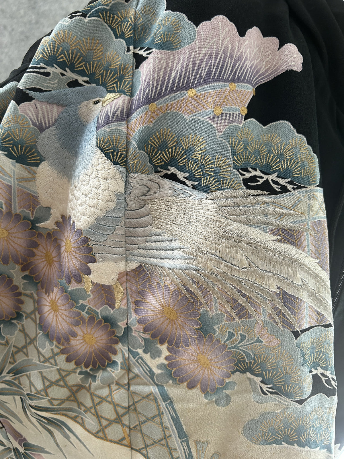 Detail of a long-tailed bird with lilac flowers and pine in pastels