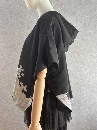 Black hooded kimono poncho with pastel flowers at the hem, side view